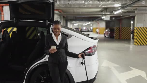 Elegantní Žena Vytáčí Číslo Smartphonu Zatímco Opírá Elektrické Vozidlo Uvnitř — Stock video