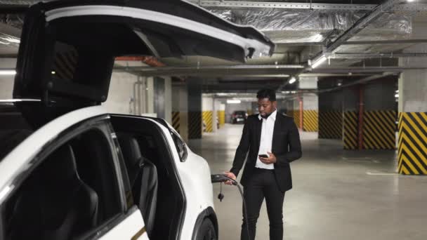 스마트 가제트를 말하는 형식적인 착용에 잘생긴 아프리카 사람은 주차장에 에너지 — 비디오