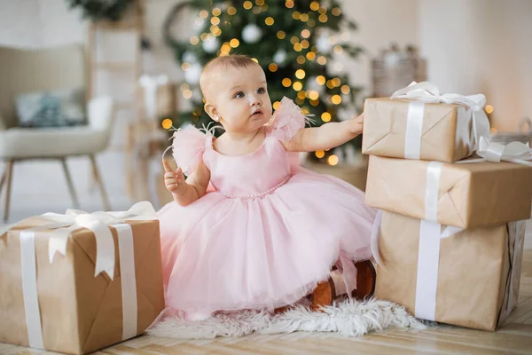 Menina Bonito Vestido Rosa Sentado Lado Belamente Embrulhado Presentes Natal — Fotografia de Stock