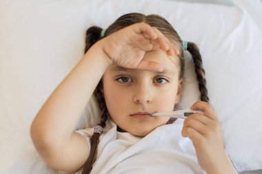 Kafkasyalı yorgun bir çocuğun portresi. Alnında iki saç örgüsü olan ve sıcaklığı elektronik termometreyle ölçen bir çocuk. Beyaz yatakta yatan ve mevsimlik virüsten muzdarip tatlı bir kız..