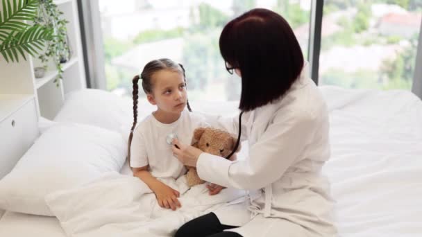 Freundliche Kaukasische Krankenschwester Mit Stethoskop Die Atemwege Des Vorschulmädchens Über — Stockvideo