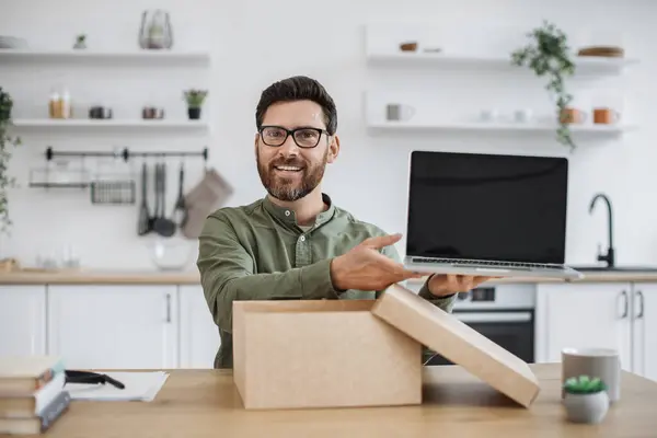 stock image Mobile web camera view of young man in casual attire doing unpacking of new portable laptop while working from home. Caucasian male blogger filming video review for his subscribers in social media.