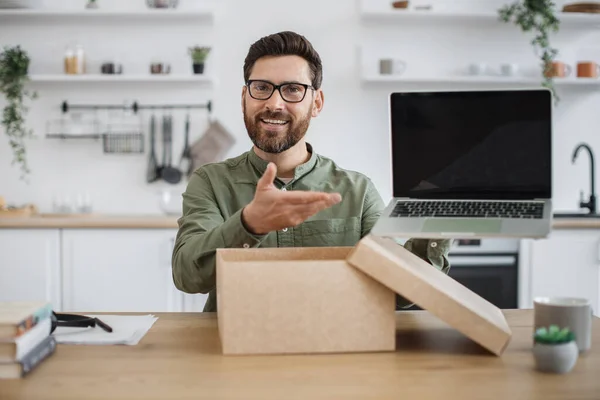 stock image Mobile web camera view of young man in casual attire doing unpacking of new portable laptop while working from home. Caucasian male blogger filming video review for his subscribers in social media.