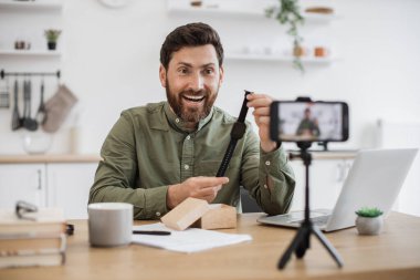 Beyaz erkek etkisinde heyecan ve mutluluk hissederek akıllı telefon kamerasından yaptığı güzel alışverişin reklamını yapıyor. Video kaydında kendine güveni olan inanılmaz bir adam uniseks saatlerinin fiyatlarını karşılaştırıyor..