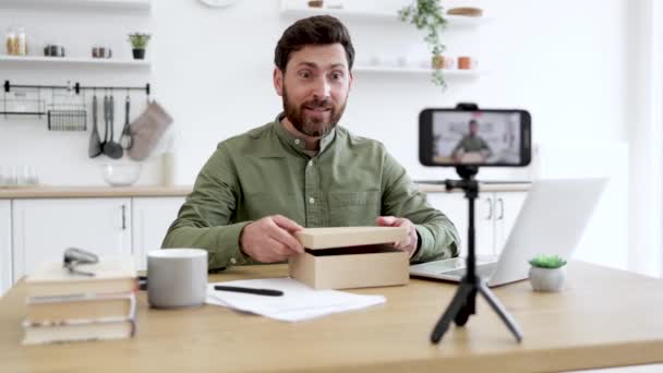 失望的博主在用手机相机展示新的控制杆的同时 也表现出充满希望的情绪 留胡子的男人在家里为社交媒体制作新的视频内容 — 图库视频影像