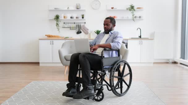 Pria Afrika Gembira Kursi Roda Memegang Laptop Berlutut Sementara Tinggal — Stok Video