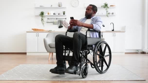 Modern Apartman Mutfağında Dinlenirken Akıllı Telefon Kullanan Özürlü Afrikalı Bir — Stok video