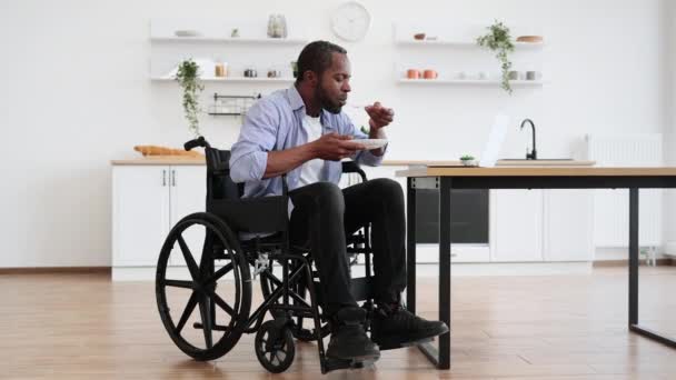 Θετικός Αφρικανός Ενήλικος Αναπηρία Που Τρώει Ενώ Κινείται Ιστοσελίδες Laptop — Αρχείο Βίντεο
