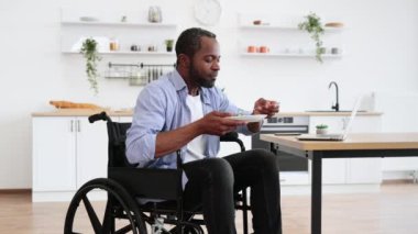 Salata, yemek odasında özürlü bir Afrikalı tarafından dizüstü bilgisayarın yanına yerleştirilmiş. Mesut işletme müdürü gün ortasında evden işe giderken sağlıklı yiyeceklerin tadını çıkarıyor..