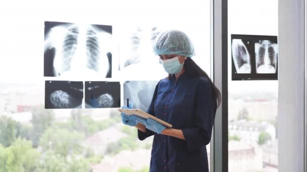 클리닉의 창문에 엑스레이를보고 특별한 외과의사의 뒤보기 검사를 디지털 태블릿을 사용하는 — 비디오