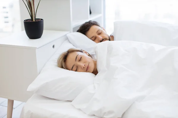 Young caucasian family of two in casual clothing having deep dream before awaking early in morning. Romantic partners sharing relationship closeness by sleeping on same sides under one blanket.