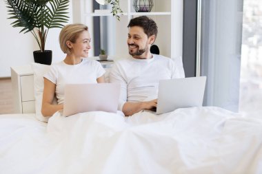 Neşeli şehvetli insanlar taşınabilir bilgisayarlara erişip hafta sonları birlikte geniş bir dairede vakit geçiriyorlar. Neşeli Kafkas ailesi kablosuz dizüstü bilgisayarlarda sosyal medyayı kaydırıyor.