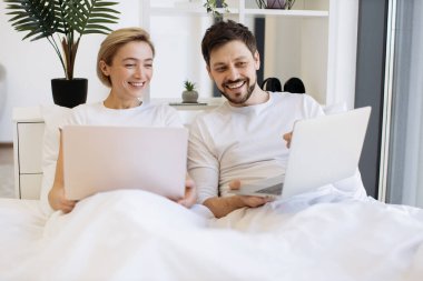 Neşeli şehvetli insanlar taşınabilir bilgisayarlara erişip hafta sonları birlikte geniş bir dairede vakit geçiriyorlar. Neşeli Kafkas ailesi kablosuz dizüstü bilgisayarlarda sosyal medyayı kaydırıyor.