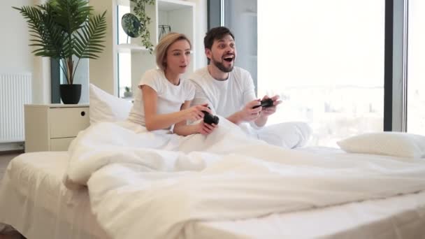 快乐的女人举起手拿着操纵杆看着丈夫在电子游戏中庆祝胜利 在在在在在在在在在在在在在在在在在在在在在玩玩玩玩玩在 — 图库视频影像