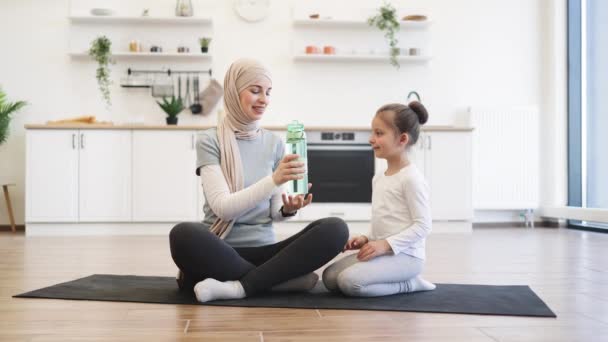 Entspanntes Muslimisches Weibchen Und Verspieltes Kleines Mädchen Mit Wasserflasche Während — Stockvideo