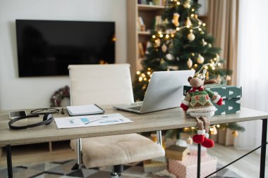 Ahşap masada modern dizüstü bilgisayar. Noel dekoru olan rahat bir ev oturma odası. Ofis masası çalışma alanı. Fotokopi alanı. Kış satışları, online alışveriş