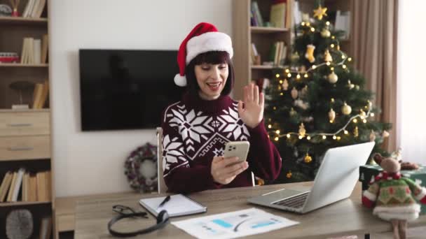 Uśmiechnięta Szczęśliwa Dorosła Kobieta Kapeluszu Mikołaja Trzymając Smartfona Podczas Rozmowy — Wideo stockowe