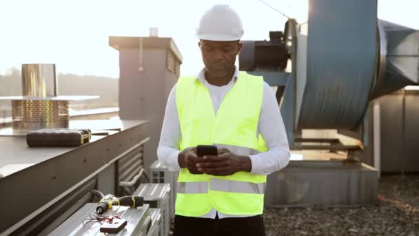 Працівник Будівництва Білому Шоломі Жилеті Стоїть Дивиться Сучасний Смартфон Свіжому — стокове відео