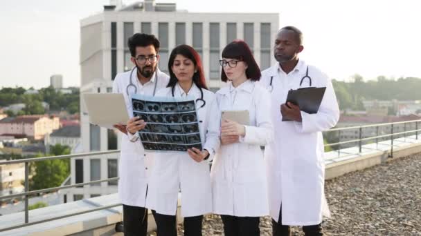 Çok Irklı Tıp Çalışanları Röntgen Taramasının Sonuçlarını Incelerken Modern Cihazlar — Stok video
