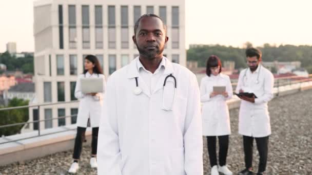 Retrato Del Joven Médico Africano Confiado Bata Laboratorio Blanca Posando — Vídeos de Stock