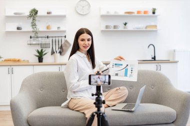 Zeki profesör canlı yayın sırasında öğrencilere döviz büyüme grafiği gösteriyor. Hevesli genç beyaz kadın öğretim üyesi cep telefonundaki video bağlantısıyla finansal okur yazarlığı öğretiyor..