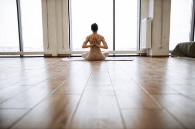 Lotus pozunda yoga yapan orta yaşlı kadınlar mı yoksa arkadan el kaldıran Padmasana mı? Meditasyon sabah spor salonunda pencerenin önünde yoga ile yapılır..