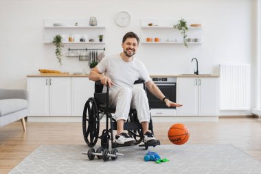 Beyaz spor giyimli mutlu Kafkasyalılar sakatlıkla aktif kalırken zevk için oyun oynuyorlar. Haftasonu stüdyo dairesinde hareketlilik bozukluğu olan neşeli sakallı bir yetişkin..