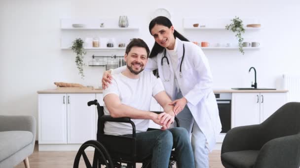 Portret Lekarza Przytulającego Uśmiechniętego Pacjenta Niepełnosprawnością Pozującego Domu Tle Jasnej — Wideo stockowe
