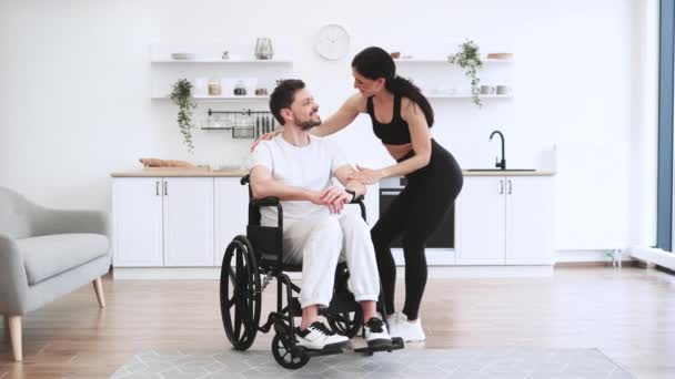 Kobieta Fizjoterapeutka Lub Żona Pomaga Młodzieńcowi Wózku Inwalidzkim Wykonywać Ćwiczenia — Wideo stockowe