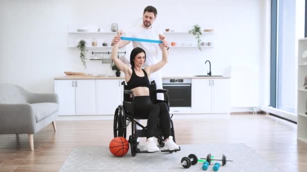 Make Sportkläder Hjälper Mogen Kvinna Rullstolslyftande Armar Med Stretchband För — Stockvideo