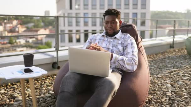 Счастливый Афроамериканец Повседневной Одежде Жестикулирует Перед Камерой Ноутбука Плоской Крыше — стоковое видео