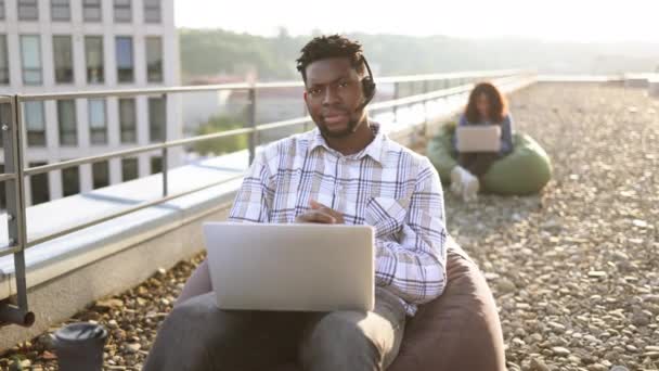 Sıradan Kıyafetlerle Gülümseyen Afro Amerikalı Bir Adam Portatif Bilgisayar Terasta — Stok video