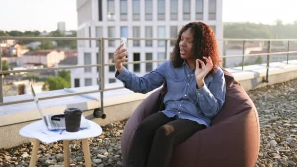 Χαρούμενη Αφρικανή Γυναίκα Casual Denim Πουκάμισο Που Χρησιμοποιεί Τηλέφωνο Ενώ — Αρχείο Βίντεο