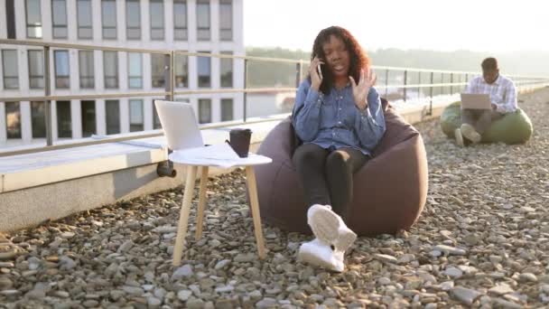Kaygısız Afrikalı Amerikalı Kadın Arka Planda Bulanık Bir Şekilde Çalışan — Stok video