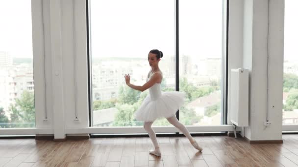 女性バレエ 現代ダンス教師クラススタジオ クラシックバレエダンサーの崇敬 美しい優雅なバレリーナ練習バレエの位置 白いライトホールの大きな窓の近くのチュチュスカート — ストック動画