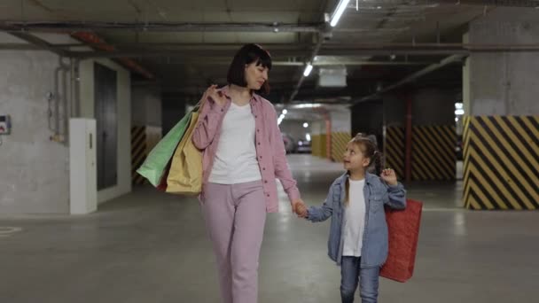Jonge Vrouw Met Klein Kind Met Kleurrijke Tassen Met Kleren — Stockvideo