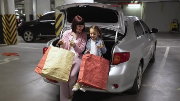 Parking Podziemny Matka Rasy Kaukaskiej Córeczka Siedzą Otwartym Bagażniku Nowoczesnego — Wideo stockowe