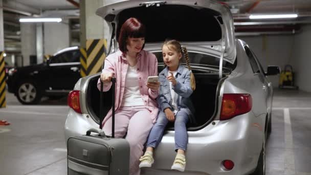 Biała Matka Córeczka Siedzą Bagażniku Nowoczesnego Samochodu Podziemnym Parkingu Młoda — Wideo stockowe