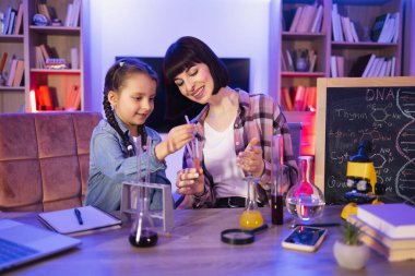Beyaz bir anne zeki kızıyla kimyasal deneyler ya da testler yapıyor. Genç bir kadın ve küçük bir kız bilgisini geliştiriyor eğlenceli bir şekilde çalışmanın, evde eğitim görmenin tadını çıkarıyor.