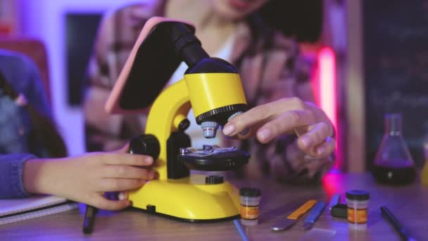 親として 教えること 夜のレジャータイムのコンセプト 新しいモダンな電子顕微鏡で働くカジュアルな摩耗で学校の娘とコーカサス母を世話する — ストック動画