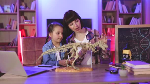 Λευκή Μητέρα Κόρη Που Κάθεται Στο Τραπέζι Και Εξετάζει Σκελετό — Αρχείο Βίντεο