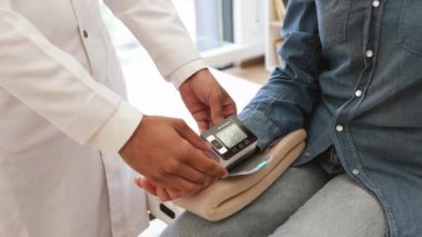 Modern klinik hastanesinde teşhis ve sağlık kontrolünden bahseden doktor ve hasta ekinleri. Elektronik ekranı olan dikkatli bir kadın erkek doktoru dikkatle dinliyor..