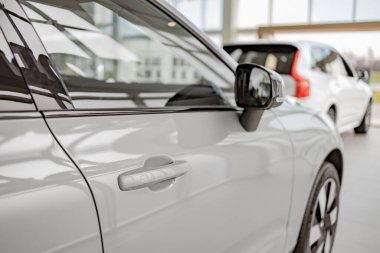 Otomobil hırsızlarına ve yüksek teknolojili otomobil modelindeki suçlulara karşı yüksek güvenlik sağlamak için kullanılan anahtarsız sistemi olan beyaz arabanın kapısına odaklan. Düşük riskli konsept.