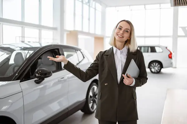 Smiling Saleswoman Holding Tablet While Looking Camera New Car Showroom Stock Picture