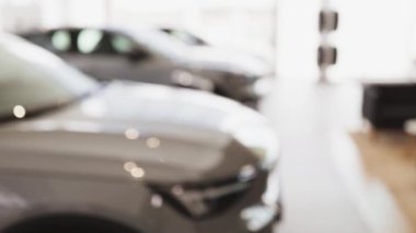 Kafkasyalı erkek araba satıcısının elindeki anahtarlar. Takım elbiseli araba satıcısı elinde anahtarlar, satılık modern araçların önünde duruyor. Teklif, indirim kavramı.