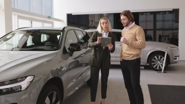 Confident Blond Saleswoman Explaining All Car Features Using Tablet Handsome — Stock Video