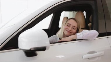 Sakin bir kadın, şoför, müşteri, tişörtlü bir müşteri açık pencereye el koyuyor, araba galerisi galerisi galerisi galerisi galerisi galerisi galerisinde kapalı motor fuarında yeni bir otomobil almak istiyor. Satış konsepti