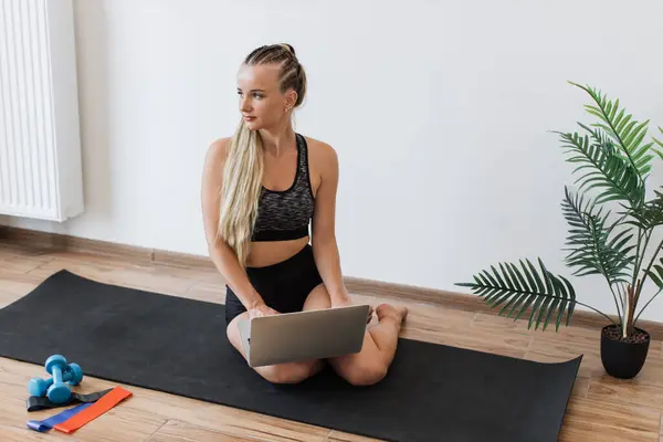 Young Woman Sportswear Sits Yoga Mat Bright Room Using Laptop Stock Image
