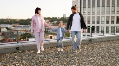 Neşeli aile çatıda kaliteli zaman geçiriyor, anne, baba ve kız şehir dışında eğleniyorlar..
