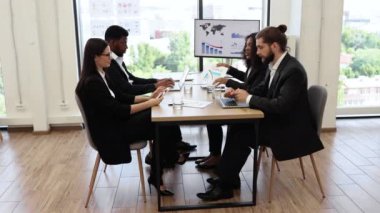 Çeşitli iş adamları modern ofiste toplantı sırasında grafikler ve grafiklerle ilgili tartışmalara girişti. İş birliği yapan, verileri analiz eden ve iş büyümesi için strateji oluşturan profesyoneller.